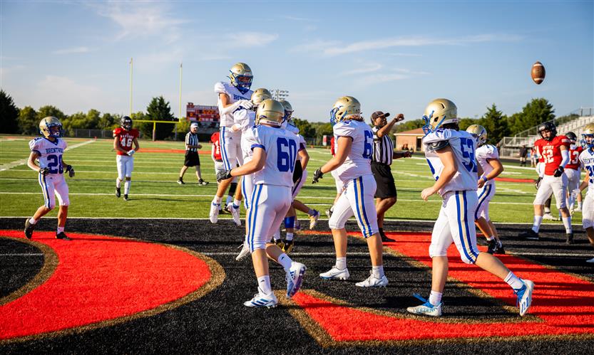 Two football players celebrate a touchdown